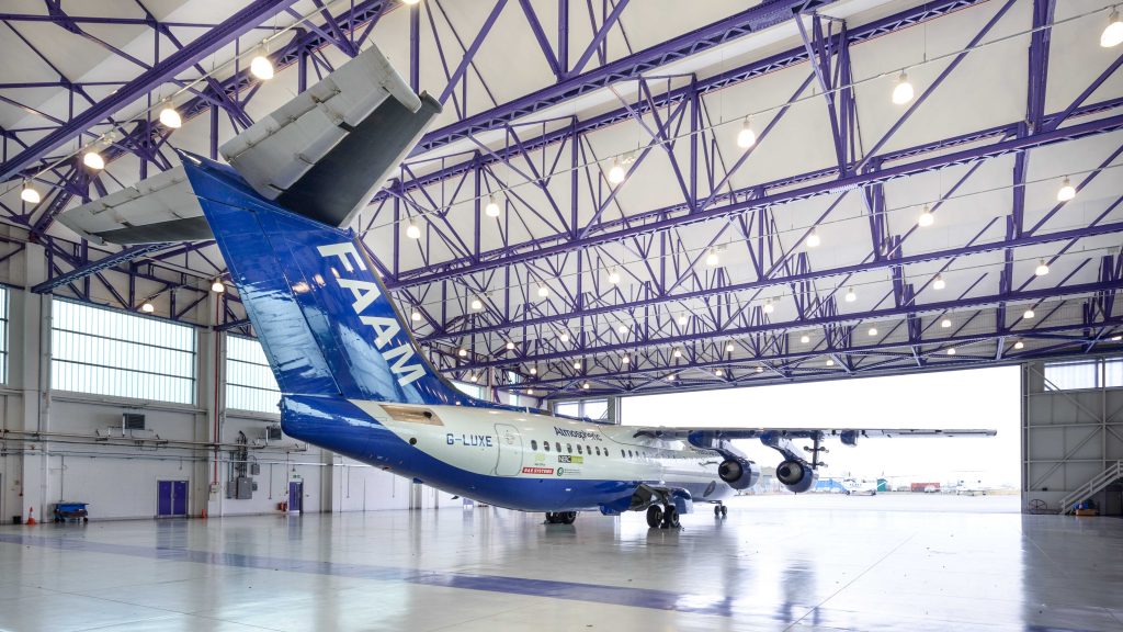 Large research aircraft, stationary in hangar, facing towards open hangar doors